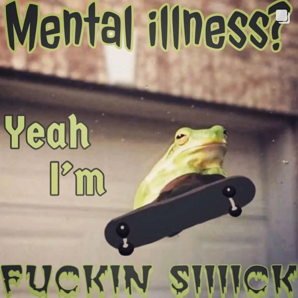 A green tree frog is perched on a black skateboard, appearing to float mid-air against a blurred background of what looks…