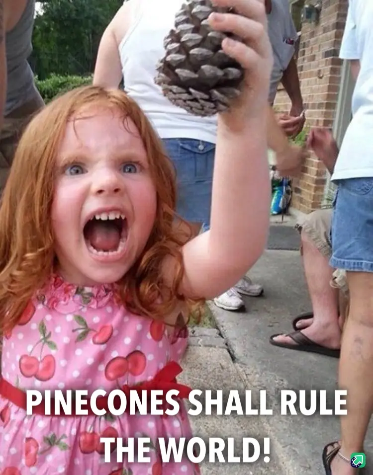 A young girl with red hair and a pink cherry-patterned dress is screaming with her mouth wide open while holding up a large…