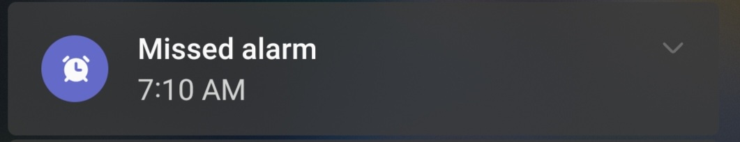 A smartphone notification banner with a blue circular icon containing a white alarm clock symbol, followed by the text…