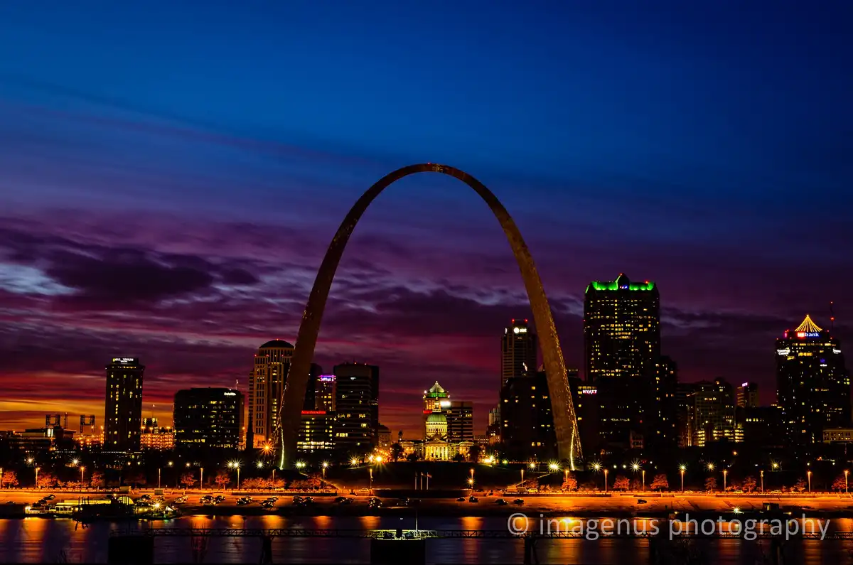 A stunning twilight photograph of the Gateway Arch in St. Louis, Missouri, silhouetted against a vibrant purple and orange…