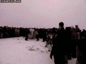 A sequence of six frames shows a large snowball rolling across a snowy field, pursued by a crowd of people who are running…