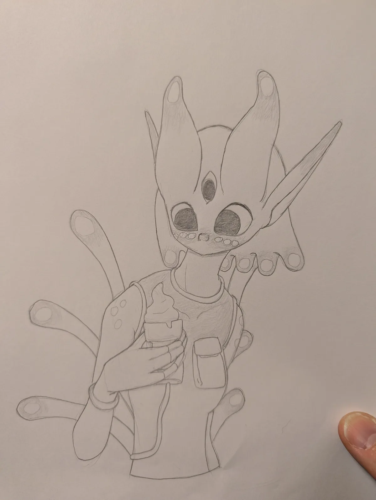 A pencil sketch of a cute, chibi-style alien creature with large eyes, multiple tentacle-like limbs, and a single horn…