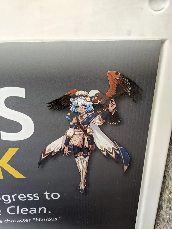 A printed promotional image shows an anime-style character with blue hair and a bird perched on her shoulder, standing…