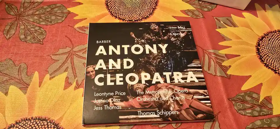 A physical copy of the opera 'Antony and Cleopatra' by Barber, released by The Metropolitan Opera, rests on a vibrant…
