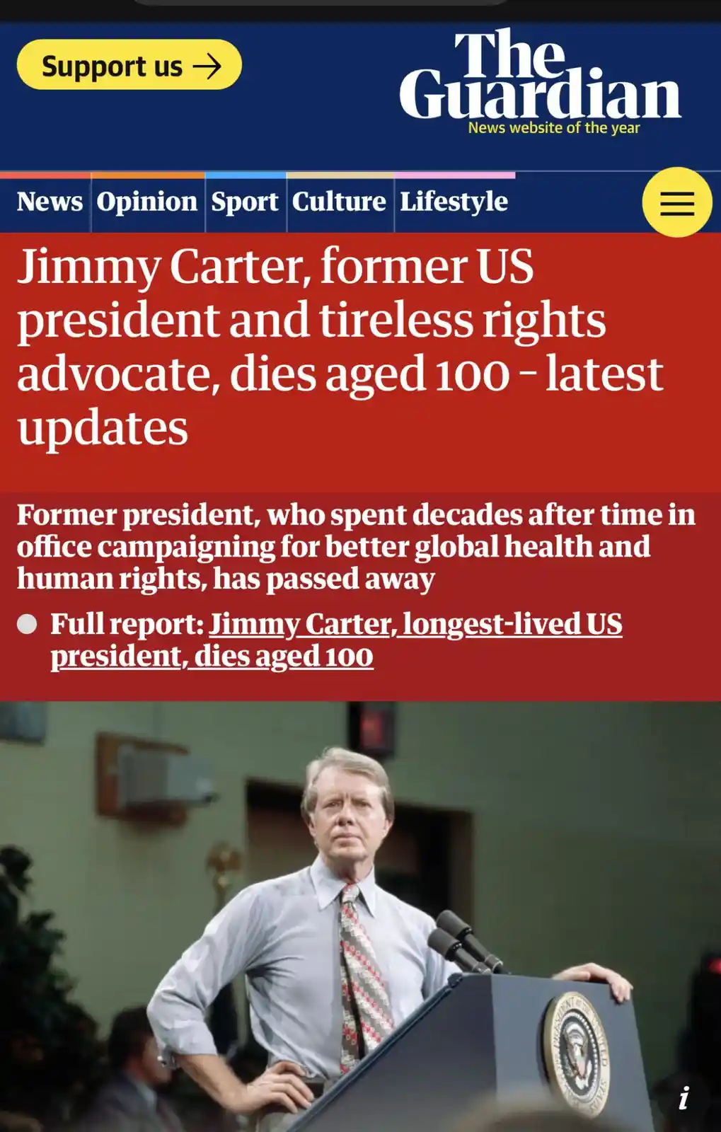 A screenshot of The Guardian's news article about Jimmy Carter's death at age 100, featuring a photo of him at a podium. The…