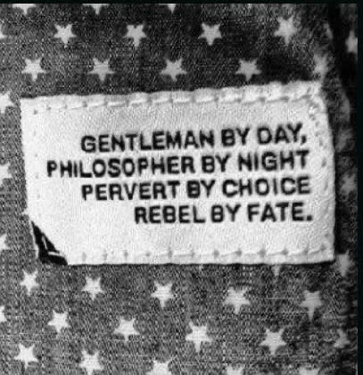 A black-and-white close-up of a fabric tag sewn onto a star-patterned textile, displaying the text 'GENTLEMAN BY DAY…