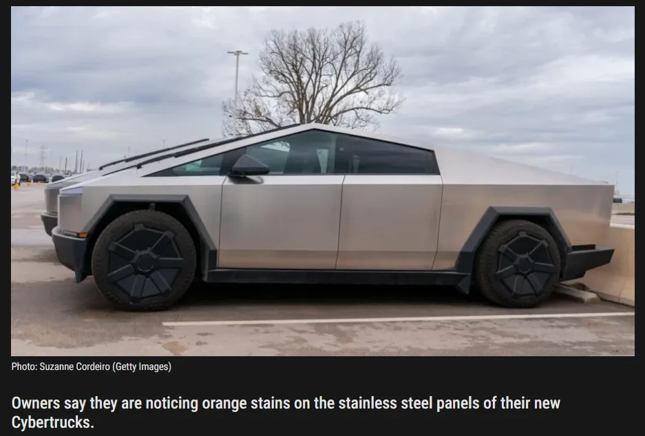 A side view of a silver Tesla Cybertruck parked in a lot under an overcast sky, showing its distinctive angular stainless…
