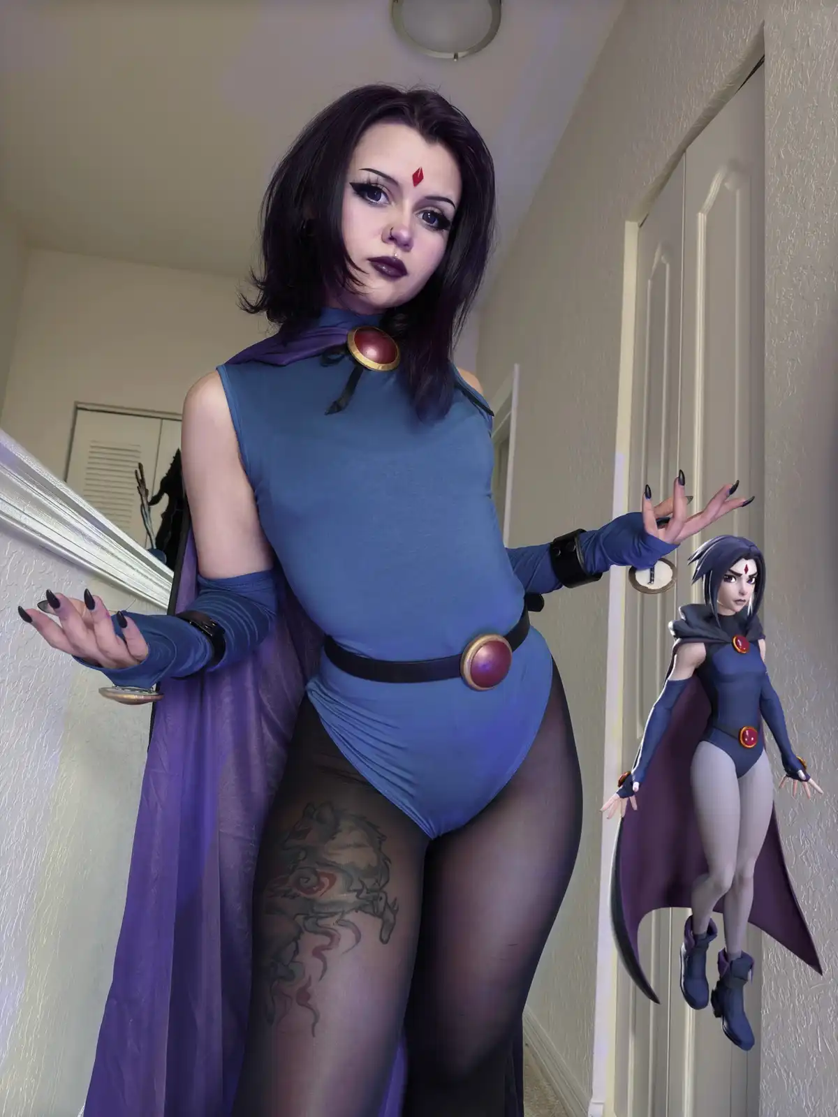 A person in a detailed Raven cosplay from Teen Titans stands in a hallway, posing with arms outstretched, next to a floating…