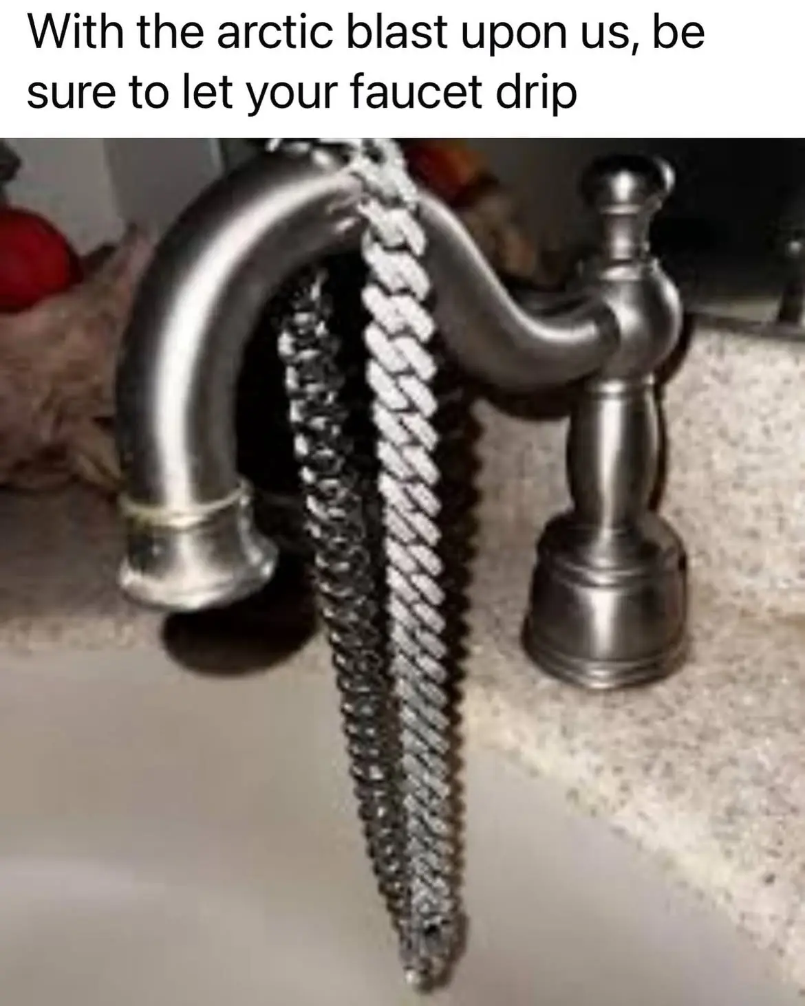A close-up photo shows a metallic faucet with a long, thick, rope-like chain of frozen water droplets hanging from its…