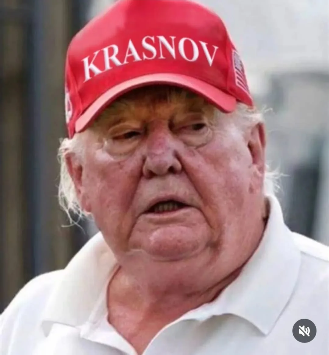A close-up photo of Donald Trump wearing a red baseball cap with the word 'KRASNOV' in white letters across the front…