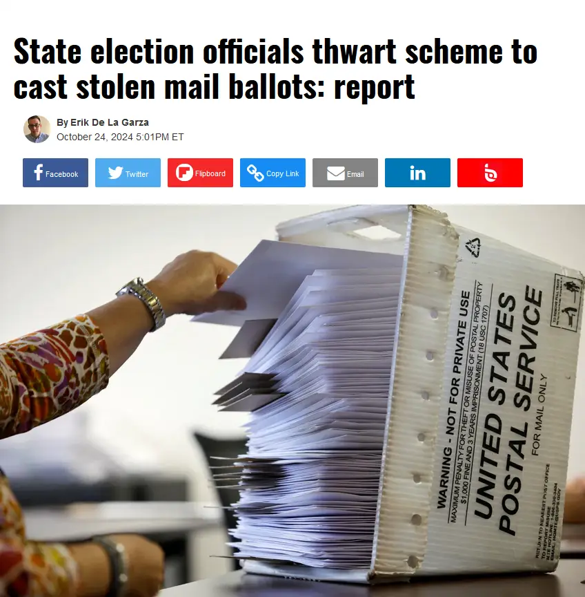 A person's hand places a mail-in ballot into a large USPS cardboard box overflowing with ballots. The box has 'UNITED STATES…