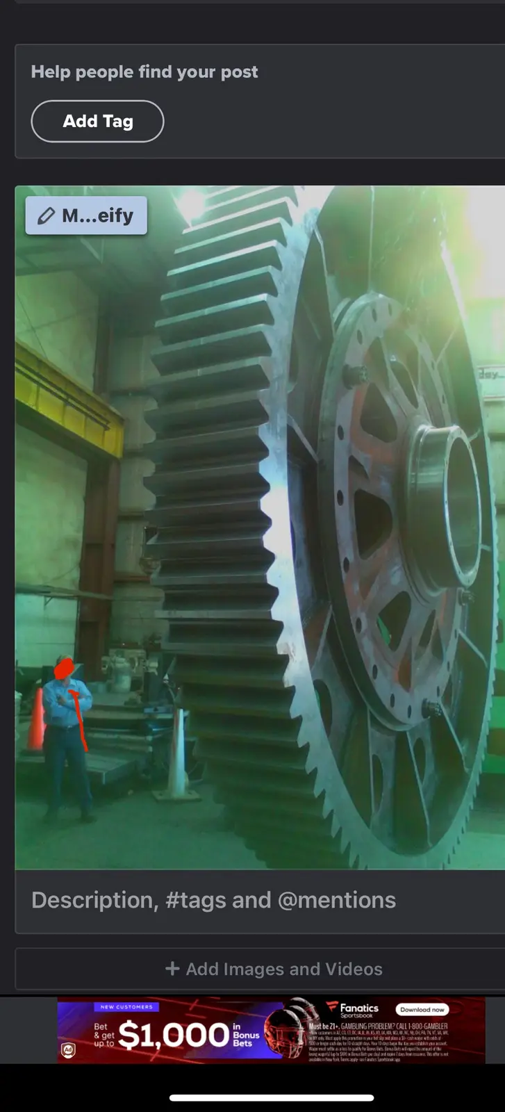A person in a blue shirt stands in a factory next to an enormous industrial gear, looking tiny in comparison. The overlaid…