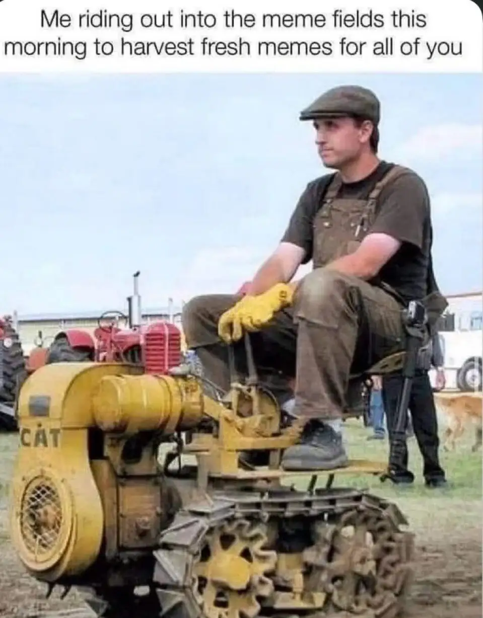 A man wearing a flat cap, overalls, and yellow gloves sits atop a yellow Caterpillar tracked vehicle, looking off to the…