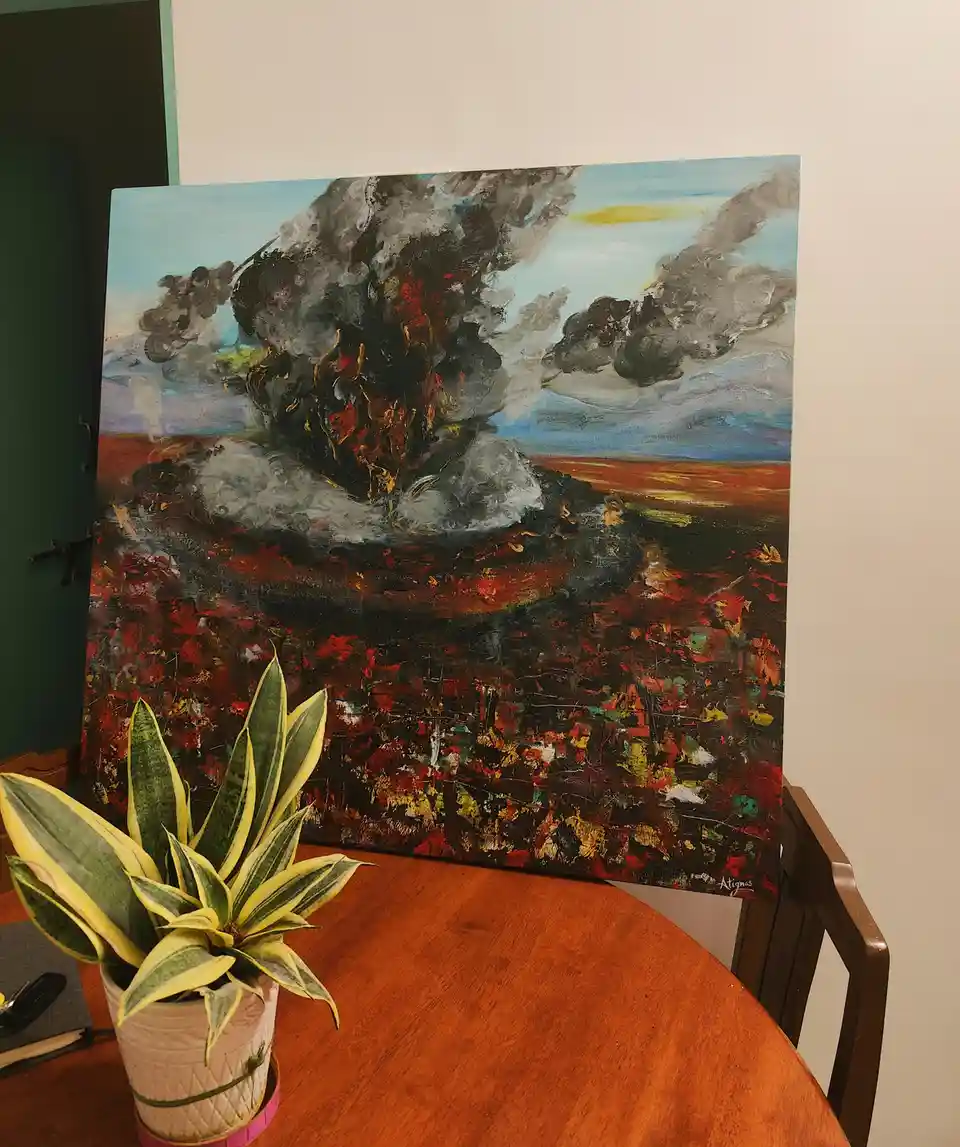 A large, dramatic painting of a volcanic eruption with dark smoke and fiery lava dominates a dining room table, leaning…
