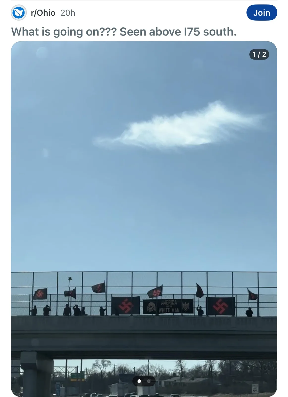 A photo from a Reddit post in r/Ohio shows a highway overpass with several people standing on it holding Nazi flags and a…