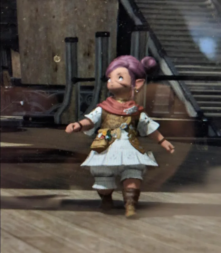 A small, purple-haired elf-like character in a white dress and brown boots walks forward in a video game setting. The…