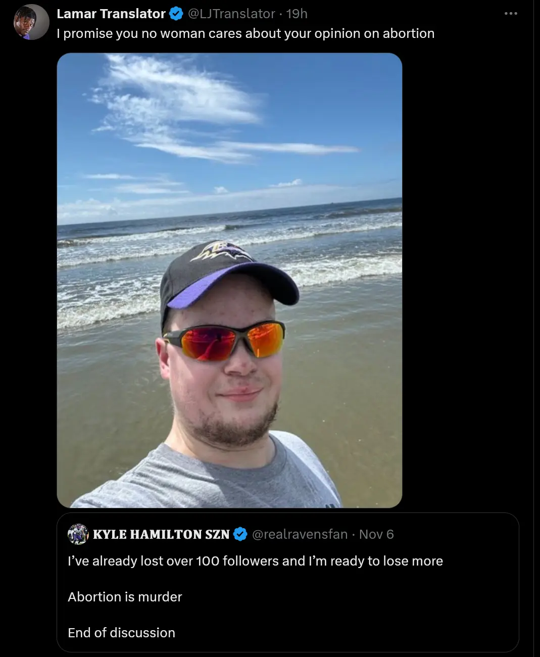 A screenshot of a Twitter thread shows a man in a baseball cap and sunglasses taking a selfie on a beach. The top tweet from…
