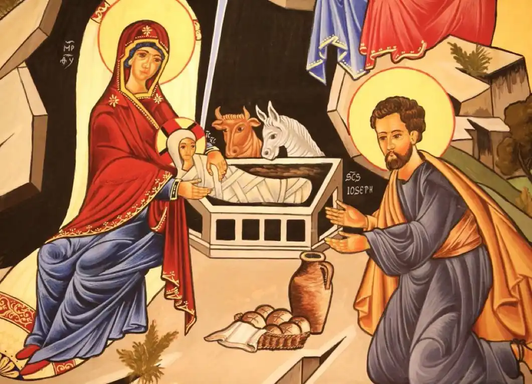 An icon-style religious painting depicts Mary in red and blue robes holding a swaddled infant in a manger, while Joseph…