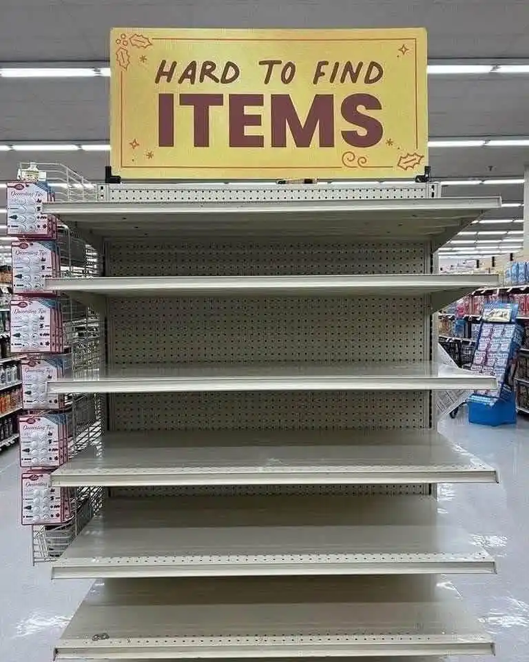 A large yellow sign reading 'HARD TO FIND ITEMS' is mounted above completely empty store shelves in a supermarket aisle. The…