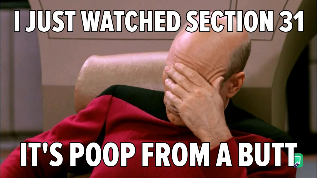 A bald man in a red uniform sits in a chair, covering his face with his hand in a gesture of despair or embarrassment. The…