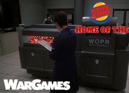 A man in a dark suit stands before a large, gray, computer-like machine labeled 'WOPR' in bold letters. The machine has…