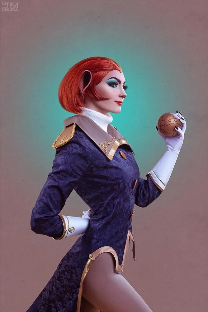 A person in a detailed cosplay of the character Lady Dimitrescu from Resident Evil Village, wearing a dark purple patterned…