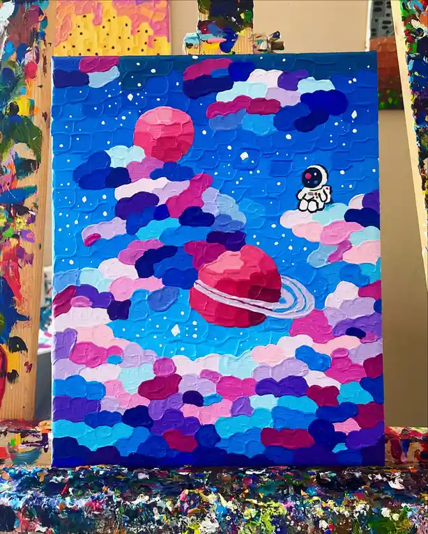 A thickly textured, colorful painting depicts a small cartoon astronaut sitting on a cloud in a vibrant blue sky filled with…