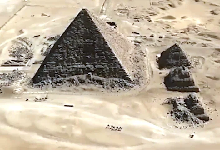 An aerial view shows the pyramids of Giza partially covered in snow, with the larger pyramid on the left and smaller ones to…