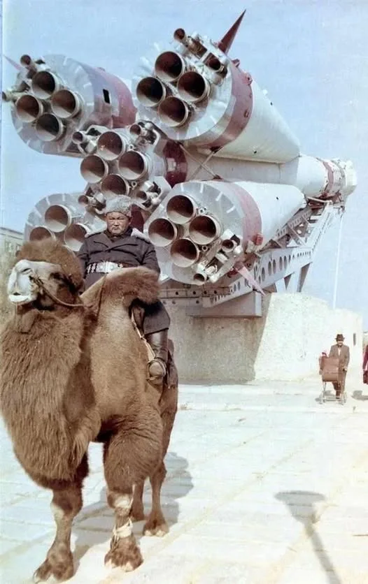 A man in traditional attire rides a camel in front of a large, complex rocket engine assembly. The overlaid text reads 'i'm…