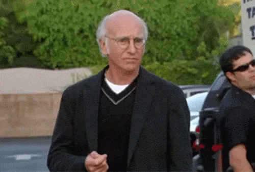 six panels show actor Larry David in a black blazer and V-neck sweater, transitioning from a neutral expression to a wide…