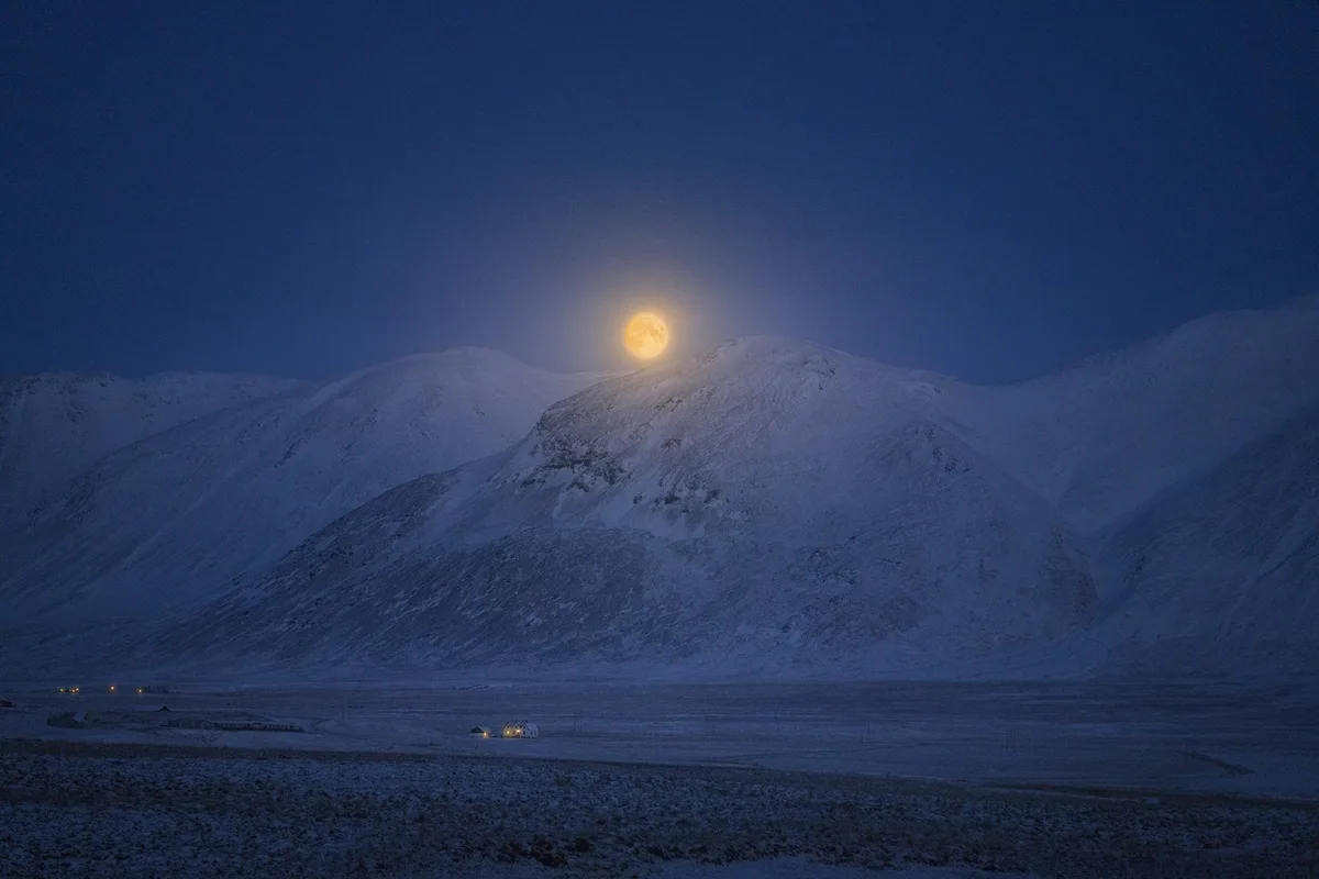 A Stunning Full Moon Rises Over Iceland's Snowy Peaks