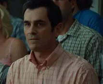 A six-panel sequence shows a man in a pink checkered shirt transitioning from a skeptical, unimpressed expression to a…