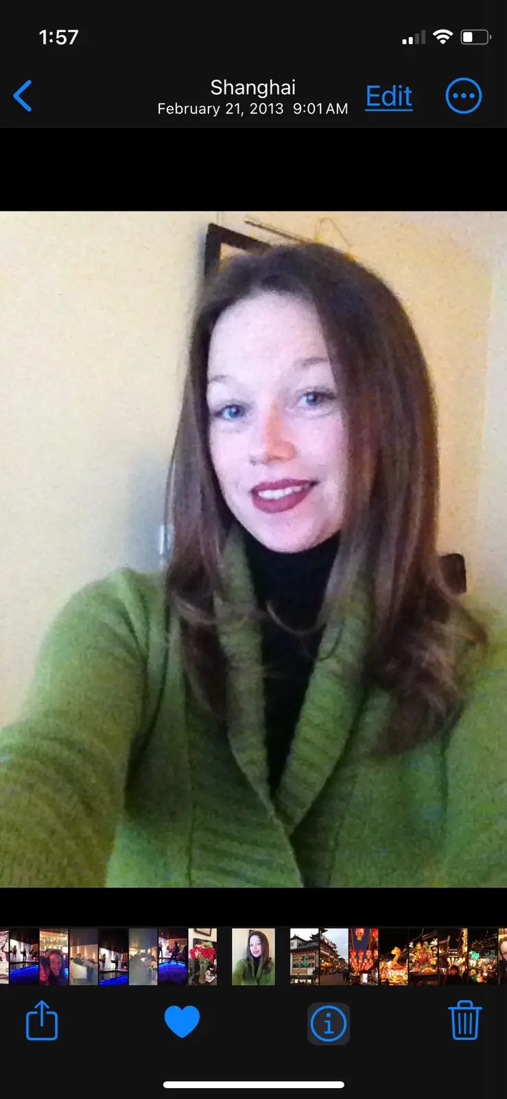 A selfie of a woman with brown hair and a green coat, taken in Shanghai on February 21, 2013, at 9:01 AM, as shown in the…