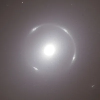 A blurry, low-resolution image shows a bright, overexposed circular light source, possibly the sun, surrounded by a faint…