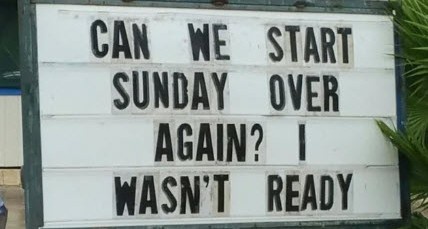 A white outdoor sign with black letter tiles reads 'CAN WE START SUNDAY OVER AGAIN? I WASN'T READY'. The sign is framed in…