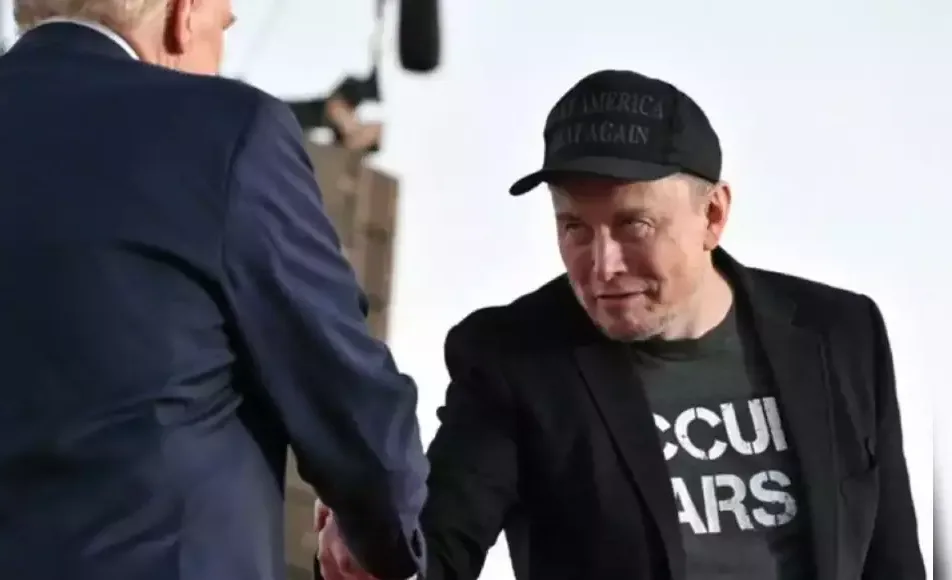 A man in a black cap with 'MAKE AMERICA GREAT AGAIN' text and a black t-shirt with partially visible white text 'CCUI ARS'…