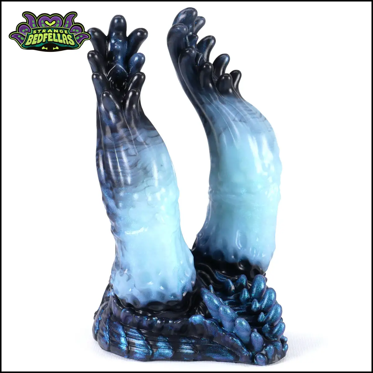 A glossy, blue-and-black resin figurine depicts two stylized, clawed hands emerging from a rocky base, with the 'Strange…