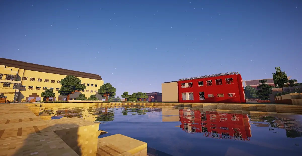 A screenshot from the game Minecraft shows a peaceful town scene with a calm body of water reflecting buildings under a…