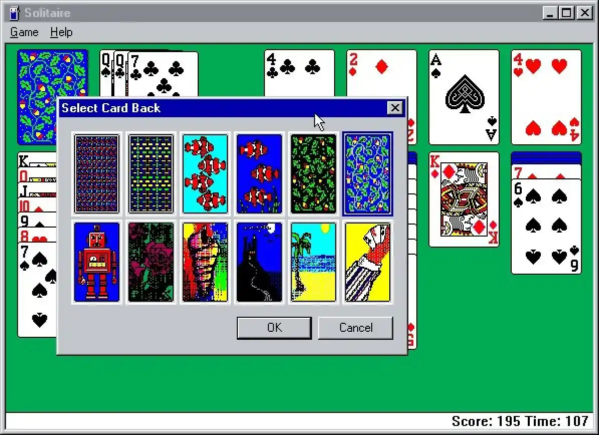 A screenshot of the classic Windows Solitaire game showing a 'Select Card Back' dialog box with nine pixelated card back…