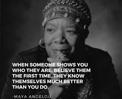 A black-and-white portrait of Maya Angelou, who is looking directly at the camera with a thoughtful expression, wearing a…