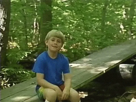 A three-panel meme showing a young boy in a blue shirt sitting on a wooden bridge in a forest. The text overlays read 'I…
