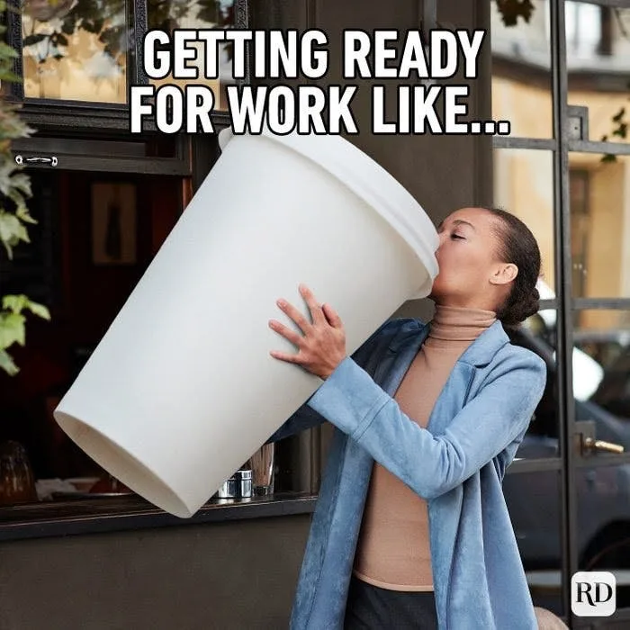 A woman in a blue blazer and beige turtleneck is standing outside a cafe, holding an enormous white coffee cup to her lips…