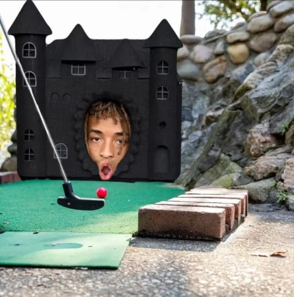 A person's face is superimposed into a hole in a black castle-shaped miniature golf obstacle, looking shocked with their…