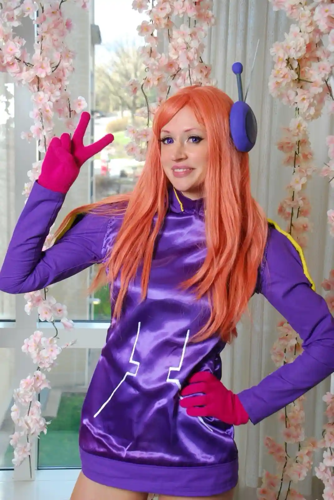 A person in a cosplay of the character Anise from the anime series 'Frieren: Beyond Journey's End' poses with one hand on…