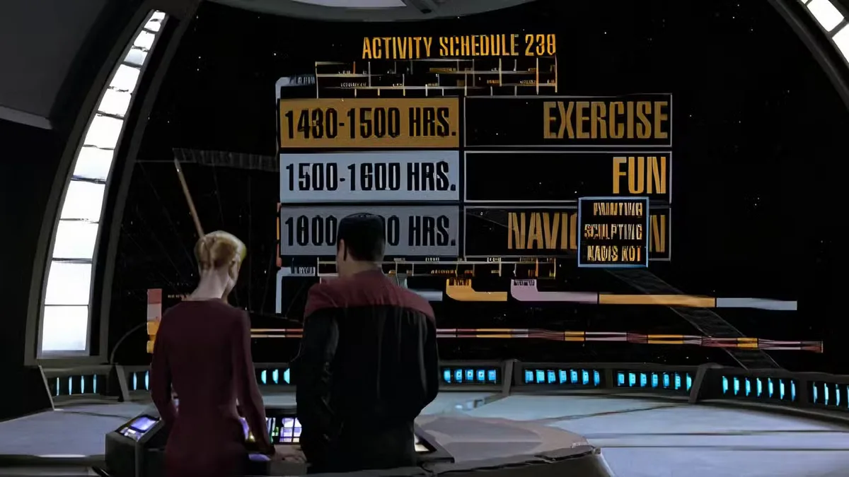 Two people in Starfleet uniforms stand before a large screen displaying an 'Activity Schedule 238' with time slots for…
