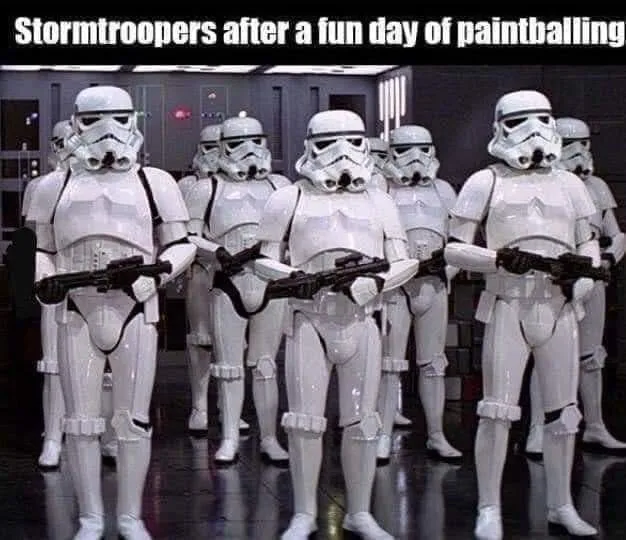 A group of Stormtroopers in full white armor stand in formation, holding blasters, with paint splatters visible on their…