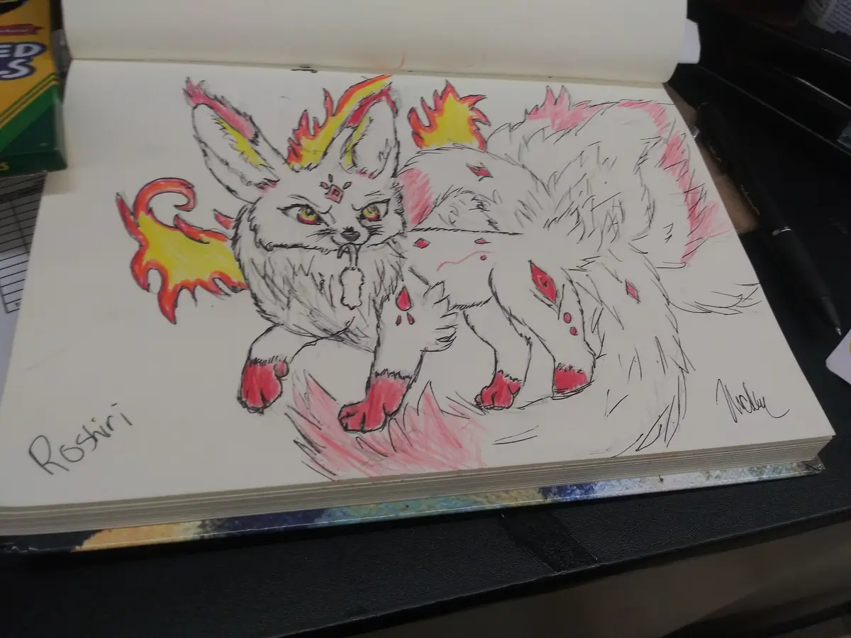 A hand-drawn illustration in a sketchbook depicts a white, fox-like creature with fiery orange and yellow flames on its…