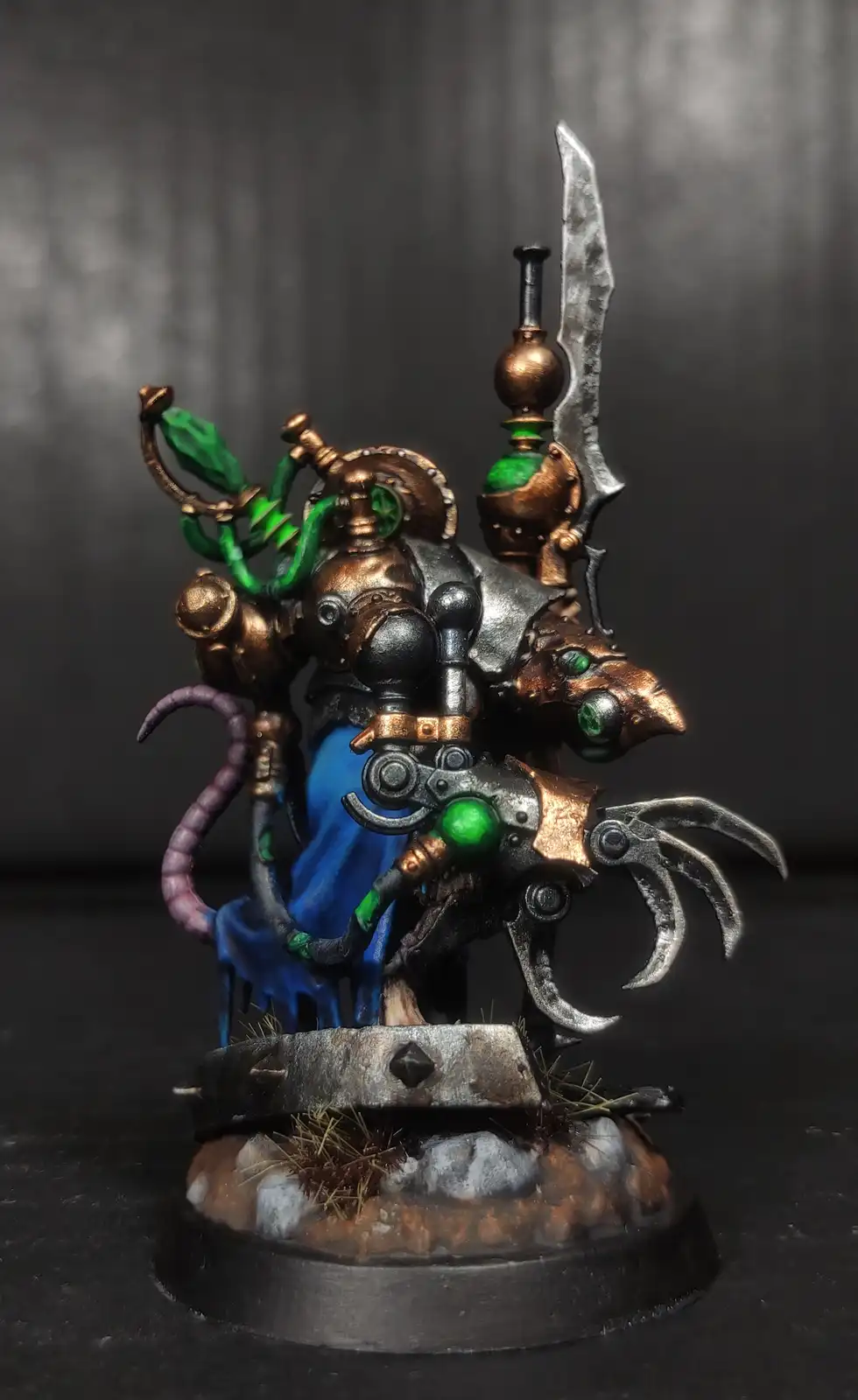 A highly detailed, painted miniature of a biomechanical, rat-like warlord with green glowing eyes, copper and silver armor…