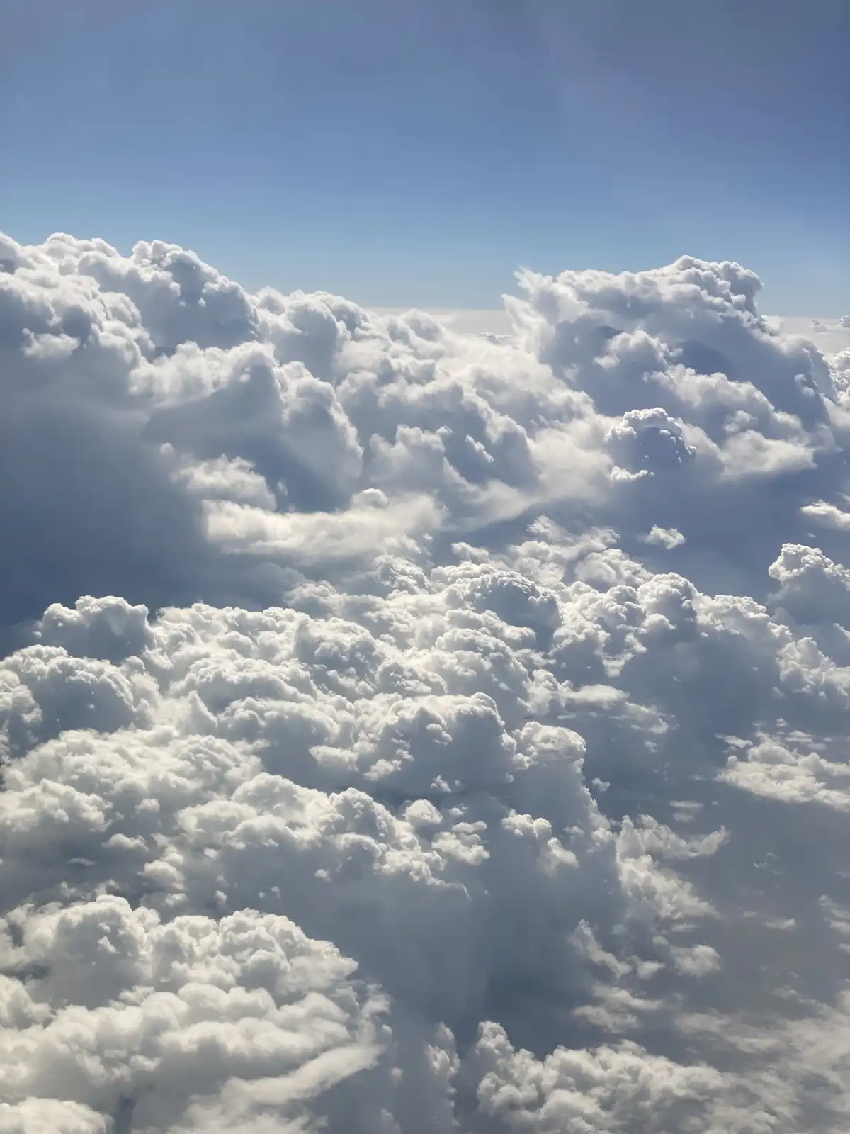 A photo taken from above a dense layer of fluffy white clouds against a clear blue sky, with the overlaid text 'i'm not…
