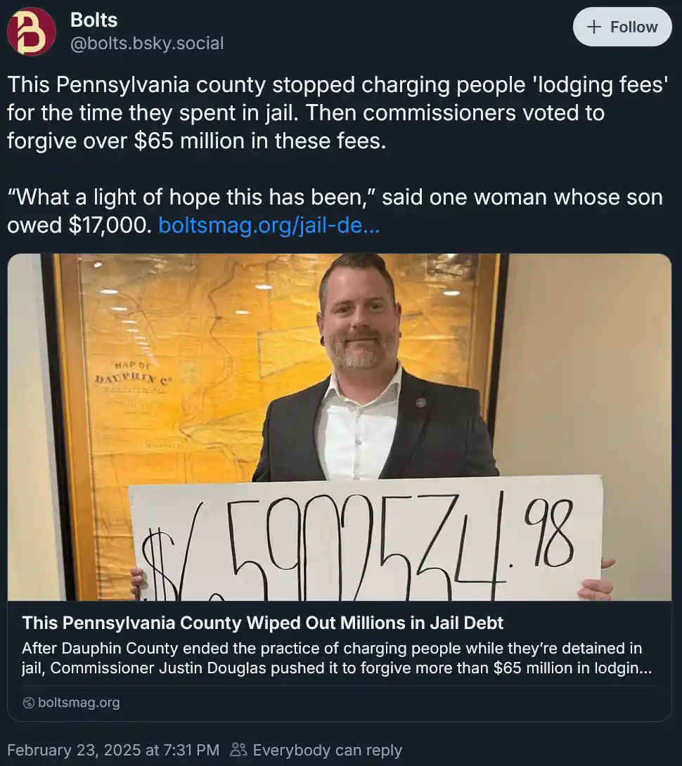 A man in a suit holds a sign displaying "$65,925,34.98". The image is overlaid with text from a news article about Dauphin…